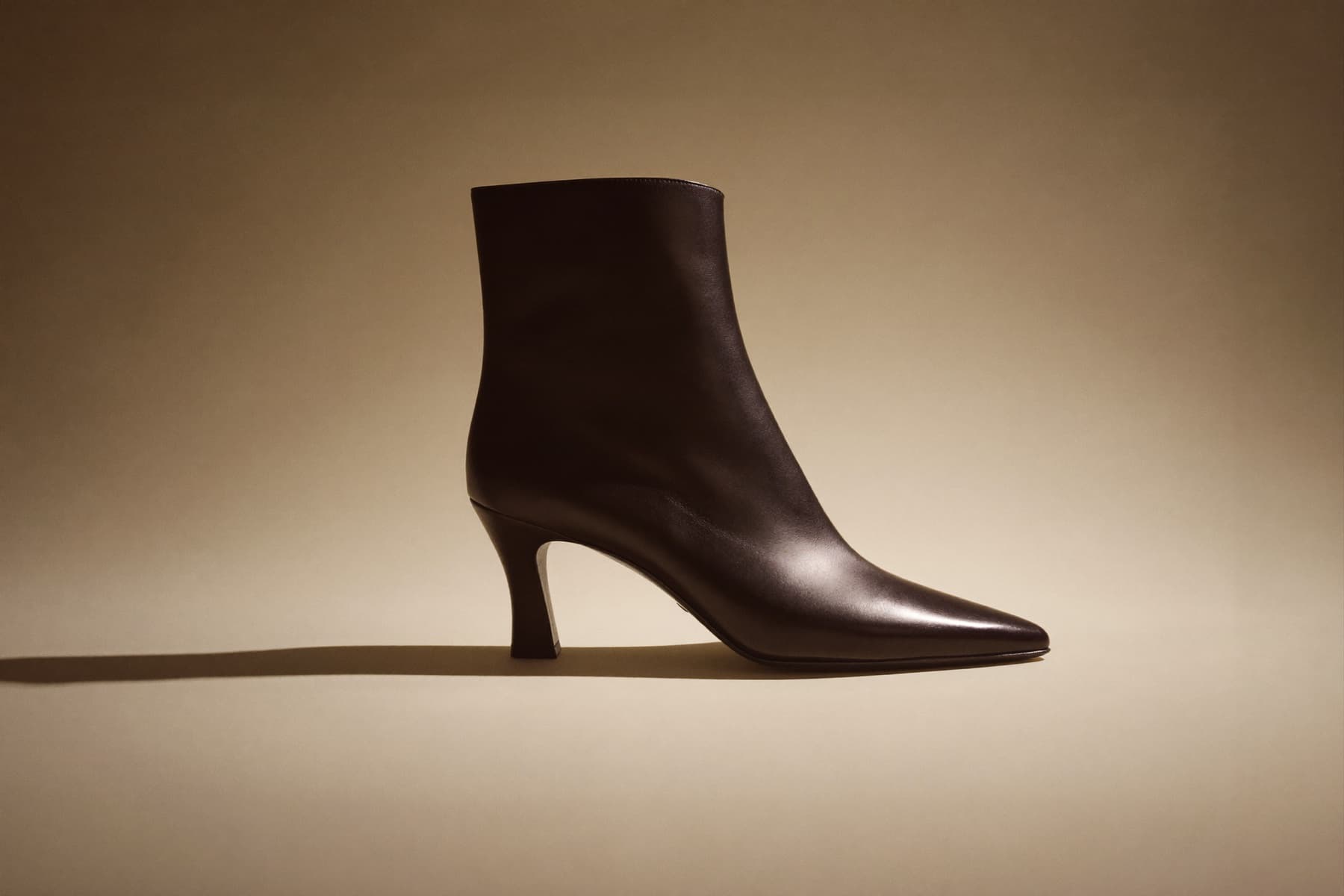 A sleek black Szya leather ankle boot, studio still life